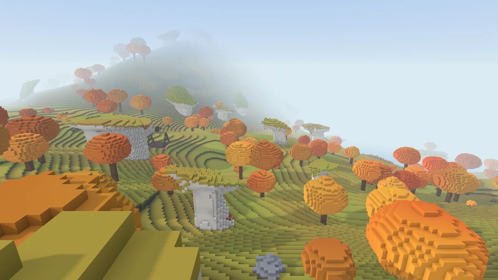 Rolling hills are covered in orange and yellow autumn trees.