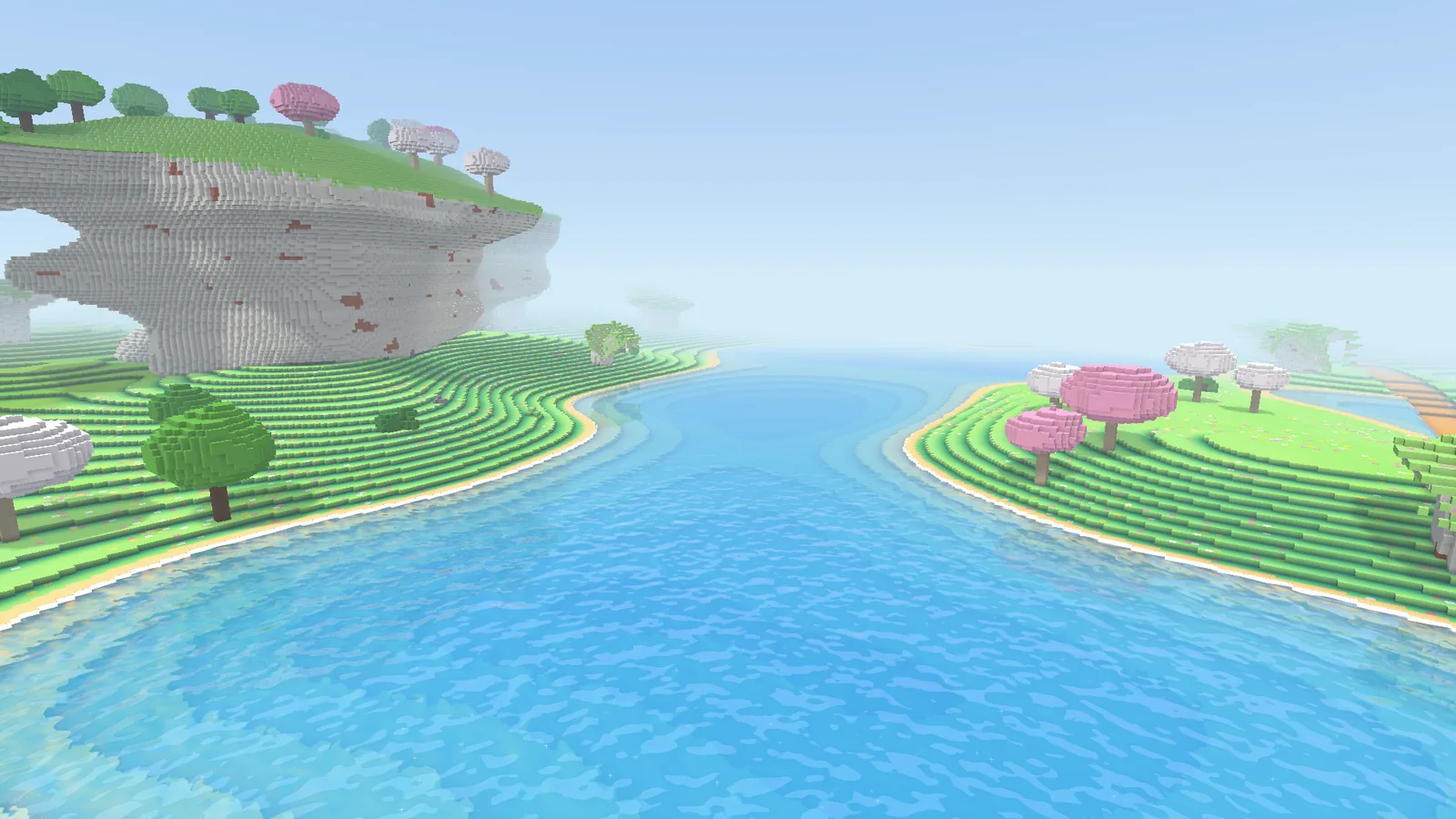 A turquoise lake lies between shores of pink blossom trees, under a great rock overhang.