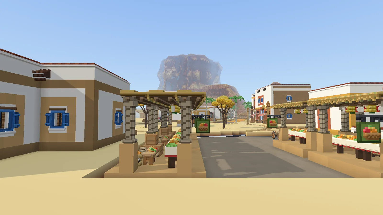 A desert town's market street runs between white houses with blue shutters, a mesa behind them.